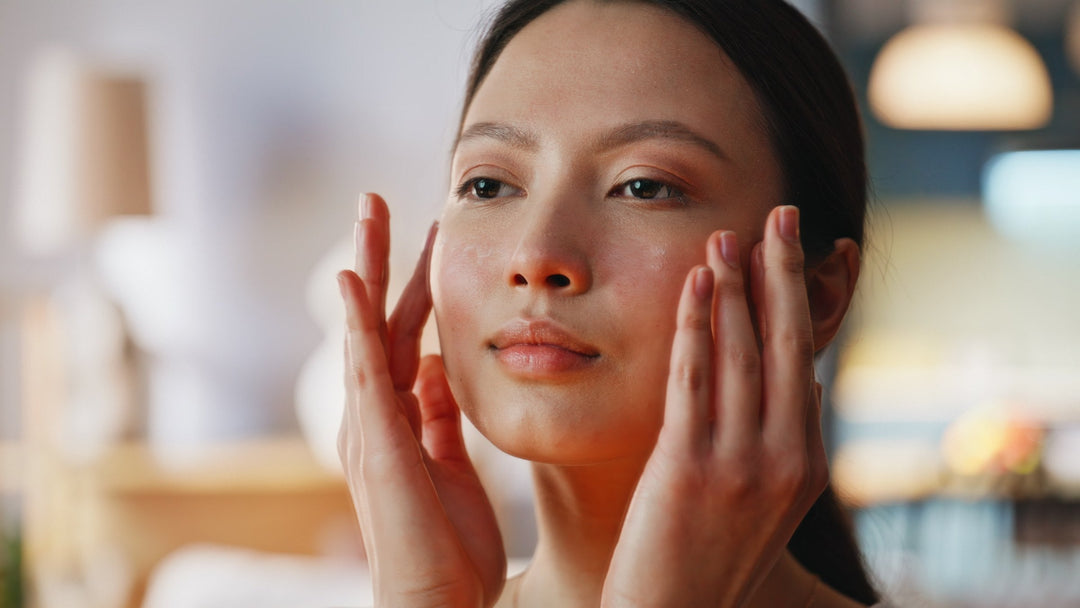 Close-up of a woman massaging serum into her face