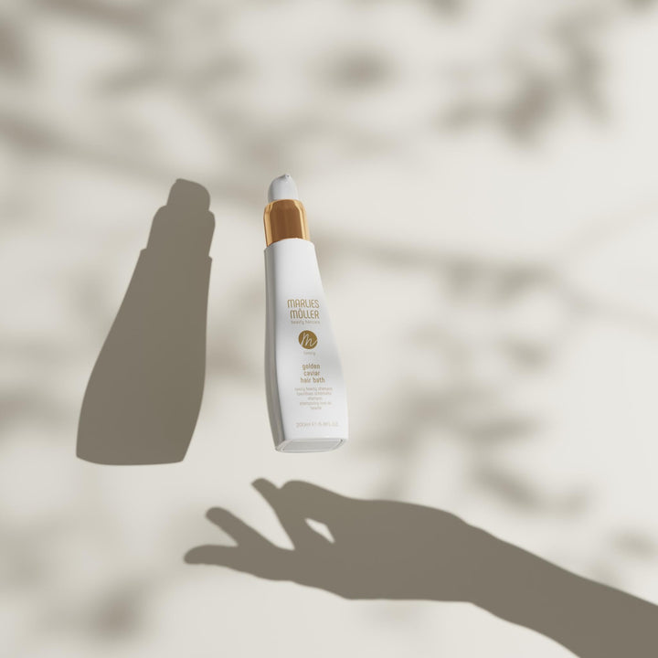 200 ml pump bottle of Golden Caviar Repair Hair Bath, amber-hued shampoo
