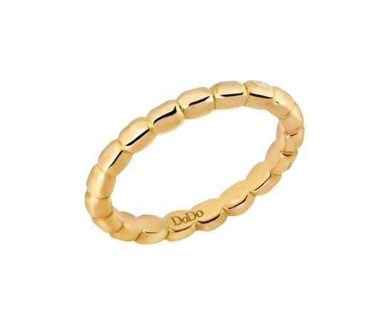 Close-up of minimalist gold beaded ring on neutral background, showing textured band and warm finish