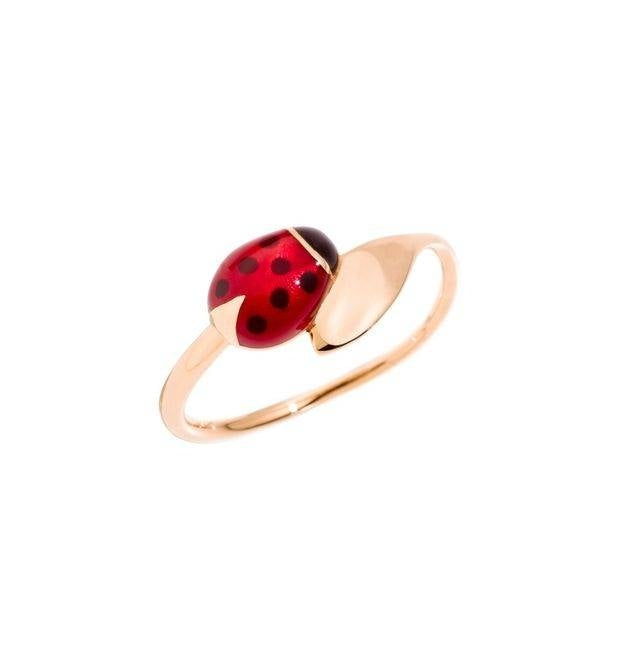 Rose gold ring featuring red and black enamel ladybug motif on polished band, close-up on glossy finish